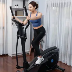 Kobieta ćwiczy na orbitreku, czerpiąc korzyści z treningu cardio.