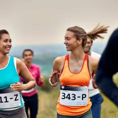 Uśmiechnięte biegaczki na trasie półmaratonu. Dobra forma i przygotowanie to klucz do sukcesu.